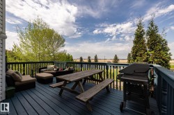 Expansive outdoor deck overlooking the 14th green at Coloniale Golf Course featuring blue-painted wood flooring and dark balusters - 