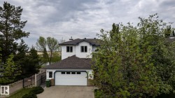 Residence featuring white siding, dark shingle roofing, and an oversized double garage - 