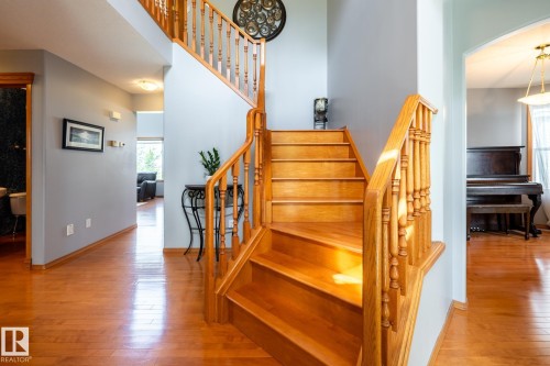 Wooden staircase with a spindle balustrade and matching wood flooring - 114 Reichert Drive, Beaumont, AB 