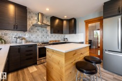 Contemporary kitchen featuring dark wood-finish cabinetry, white countertops, and a patterned tile backsplash - 