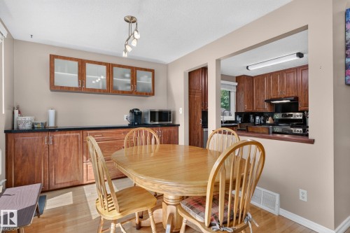 Dining area featuring wood-finish flooring and a contemporary light fixture - 31 Alpine Boulevard, St. Albert, AB 