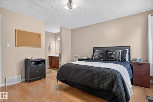 Bedroom featuring wood-finish flooring, neutral wall tones, and a built-in recessed ceiling light fixture - 31 Alpine Boulevard, St. Albert, AB 