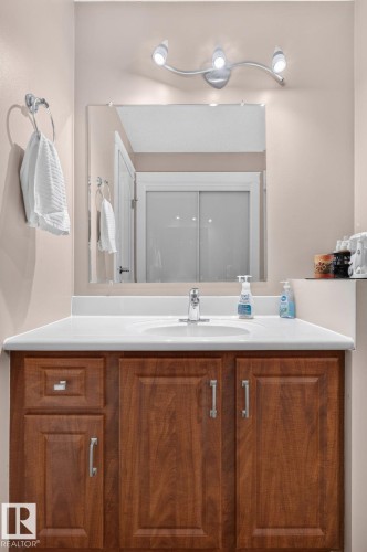 Vanity with rich wood-finish cabinetry and brushed nickel hardware - 31 Alpine Boulevard, St. Albert, AB 