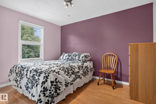 Bedroom featuring a single window, a textured ceiling, wood-finish flooring, and a track lighting fixture - 31 Alpine Boulevard, St. Albert, AB 