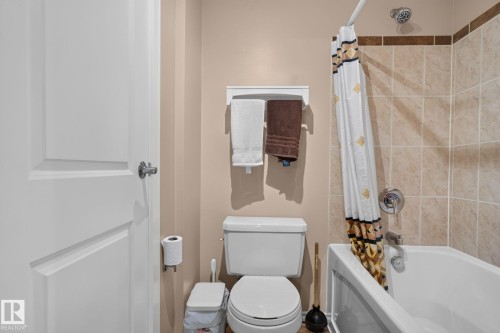 Bathroom featuring a white bathtub, ceramic tile surround, and a chrome showerhead - 31 Alpine Boulevard, St. Albert, AB 