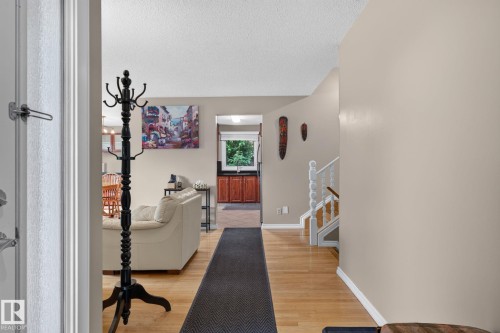 Foyer featuring hardwood flooring, neutral wall tones, and a staircase with white balusters - 31 Alpine Boulevard, St. Albert, AB 