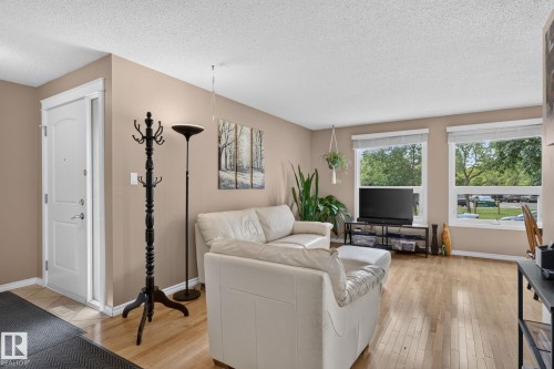 Light wood-finish flooring extends through this room, complemented by a muted wall color and white trim - 31 Alpine Boulevard, St. Albert, AB 