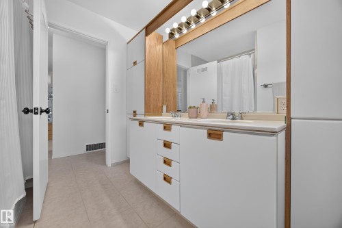 Dual vanity featuring white cabinetry with wood-finish hardware and a light-toned countertop - 3411 103 Avenue, Edmonton, AB 