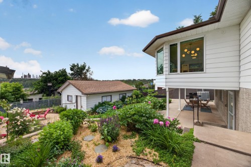 Tiered backyard featuring mature landscaping and a detached auxiliary building - 3411 103 Avenue, Edmonton, AB 