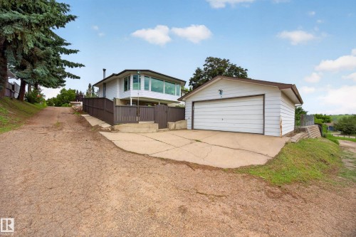 Detached garage with white siding and a brown roof, featuring a concrete driveway - 3411 103 Avenue, Edmonton, AB 