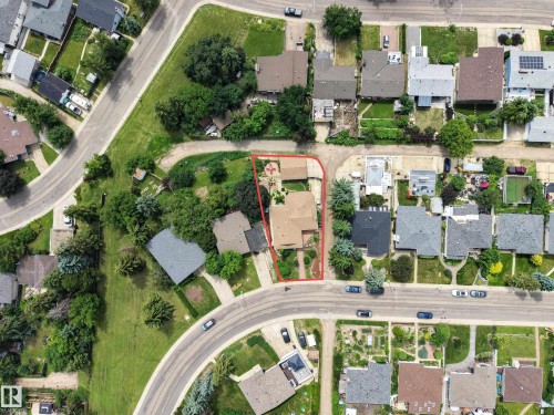 Aerial perspective showcasing a residential property with a detached garage, established landscaping, and a curvilinear street frontage - 3411 103 Avenue, Edmonton, AB 