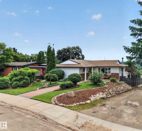Single-story residence featuring a white siding exterior with brick accents and a brown shingle roof - 3411 103 Avenue, Edmonton, AB 