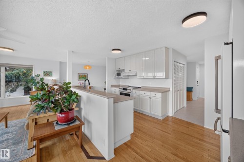 Contemporary kitchen featuring white cabinetry, light countertops, and a black faucet - 3411 103 Avenue, Edmonton, AB 