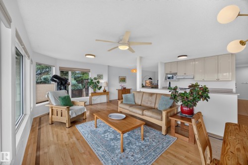 Open-concept living area with wood-finish flooring, a ceiling fan, and recessed lighting - 3411 103 Avenue, Edmonton, AB 