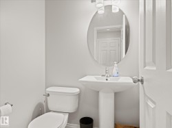 Pedestal sink with a polished chrome faucet and an oval mirror - 