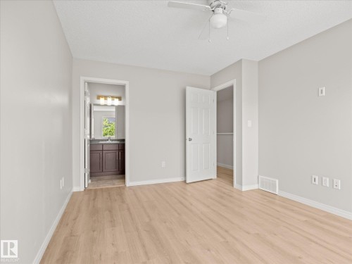 Spacious room featuring light wood-finish flooring, neutral wall tones, and a ceiling fan with light fixture - 473 Orchards Boulevard, Edmonton, AB 