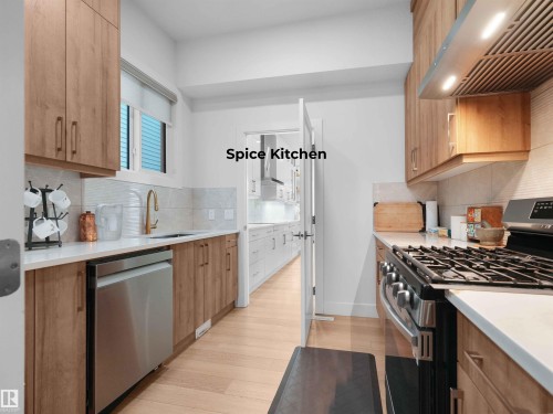 Functional spice kitchen space featuring wood-finish cabinetry, light countertops, and a full suite of stainless steel appliances including a gas range and dishwasher - 320 38 Street, Edmonton, AB 