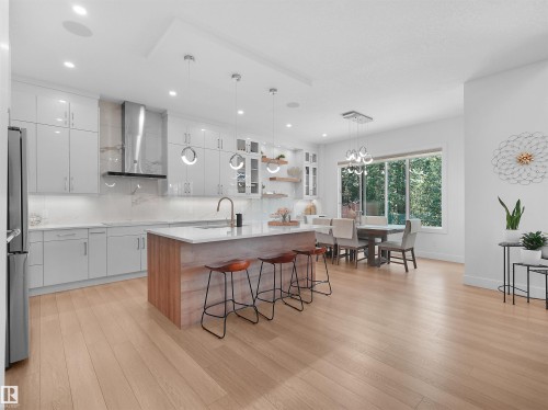 Open-concept kitchen and dining area featuring a light-finish wood flooring - 320 38 Street, Edmonton, AB 