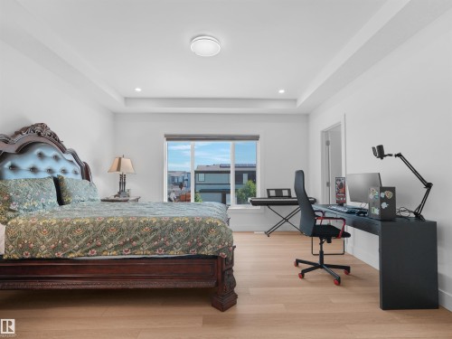 Recessed ceiling with integrated lighting, wood-finish flooring, and a large window providing natural light - 320 38 Street, Edmonton, AB 