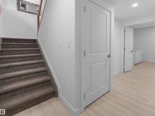 Carpeted staircase with wooden handrail, leading to an upper level - 320 38 Street, Edmonton, AB 