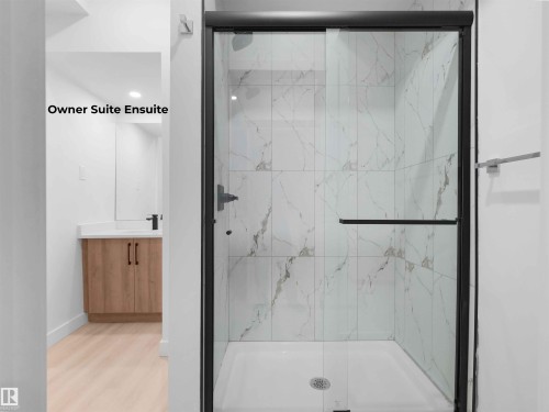 Modern shower enclosure with black-framed glass door, white subway tile surround, and black fixtures - 320 38 Street, Edmonton, AB 