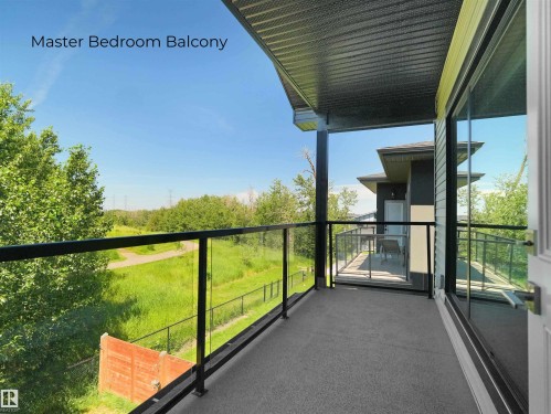 Private balcony featuring glass railings, composite decking, black support beams, and direct outdoor access - 320 38 Street, Edmonton, AB 