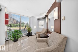 Bright reception area featuring large windows with horizontal blinds, neutral floor tiles, and recessed lighting - 