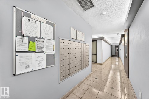 Entryway corridor featuring a built-in mailbox system, light-toned tiled flooring, and a neutral color palette - 806 10545 Saskatchewan Drive, Edmonton, AB 