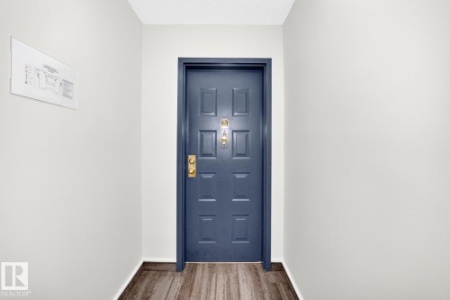 Paneled door with brass hardware and wood-finish flooring - 806 10545 Saskatchewan Drive, Edmonton, AB 