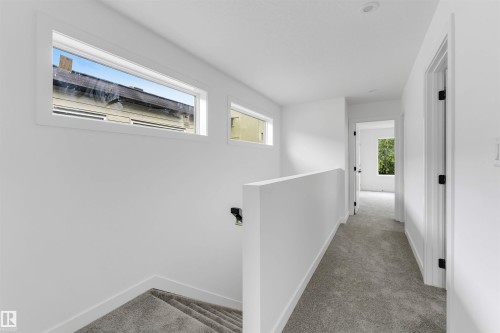Upper-level hallway featuring plush gray carpeting, white walls, and recessed lighting - 3605 112 Ave, Edmonton, AB 