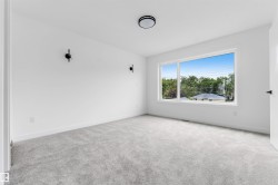 Bright interior space featuring a large picture window, light gray carpet, white walls, and a contemporary flush-mount ceiling light - 