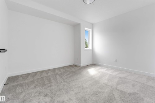 Room with light gray patterned carpet, white walls, and a single window offering natural light - 3605 112 Ave, Edmonton, AB 