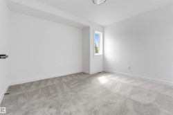 Room with light gray patterned carpet, white walls, and a single window offering natural light - 