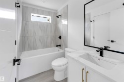 Bathroom featuring a white vanity with a rectangular undermount sink, a countertop, and a matte black faucet - 