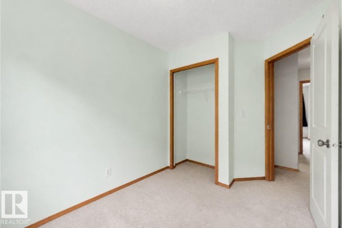 Interior room featuring light green walls, light-colored carpet flooring, and natural wood trim - #28 290 Spruce Ridge Rd, Spruce Grove, AB - Indoor Photo Showing Other Room