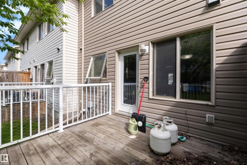 Rear exterior deck featuring wood-finish flooring, white railing, and direct access through a white door - #28 290 Spruce Ridge Rd, Spruce Grove, AB - Outdoor With Deck Patio Veranda With Exterior