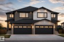 Modern duplex facade featuring mixed material construction with stone accents, dark siding, and white paneling - 3618 40 Avenue, Beaumont, AB  - Outdoor 