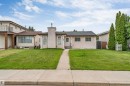 Exterior featuring a stucco facade, central entryway, and a chimney structure - 193 Woodvale Road W, Edmonton, AB 