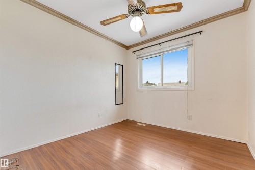 Room featuring wood-finish flooring, a ceiling fan with integrated lighting, and crown molding - 193 Woodvale Road W, Edmonton, AB 