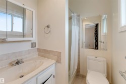 Bathroom featuring a white vanity with integrated sink, tiled backsplash, and medicine cabinet - 