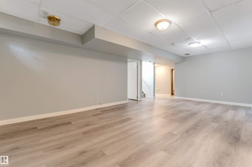 Spacious interior featuring light wood-finish flooring, light gray walls, and white trim - 193 Woodvale Road W, Edmonton, AB 