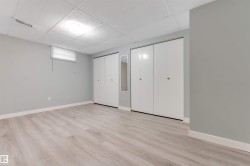 Spacious room featuring light wood-finish flooring, light gray walls, and white baseboards - 