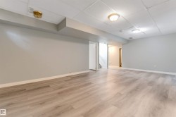 Spacious interior featuring light wood-finish flooring, light gray walls, and white trim - 