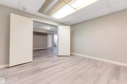 Brightly lit room featuring light wood-finish flooring, neutral wall paint, and white trim - 