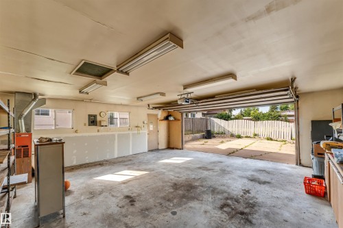 Spacious garage featuring a concrete floor, fluorescent ceiling lighting, and exposed ceiling joists - 193 Woodvale Road Nw, Edmonton, AB - Indoor Photo Showing Garage