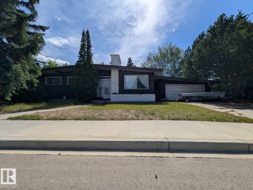 Single-story residence featuring a dark facade with white brick accents, a prominent chimney, and a single-car garage - 4632 113A Street, Edmonton, AB 