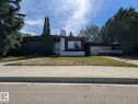 Single-story residence featuring a dark facade with white brick accents, a prominent chimney, and a single-car garage - 4632 113A Street, Edmonton, AB 
