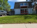 Front exterior featuring a gambrel roofline, white siding, and upper and lower-level windows - 4632 113A Street Nw, Edmonton, AB 