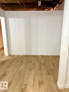 Light wood-finish flooring with white baseboards and walls - 