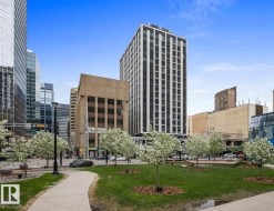 Urban park setting featuring a paved pathway, manicured green spaces, and mature trees - 